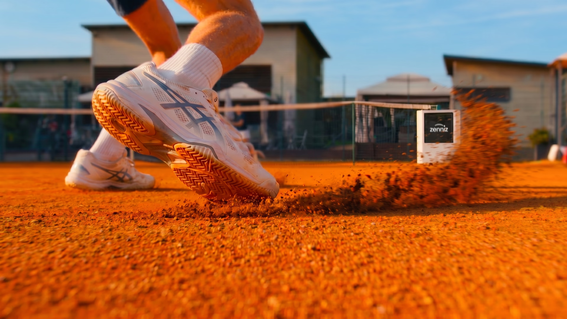 Tennissko på grusbane med Zenniz-system i baggrunden